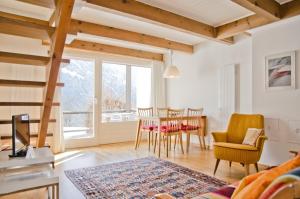 een woonkamer met een tafel en stoelen bij Apartment Nussbaum - GRIWA RENT AG in Grindelwald