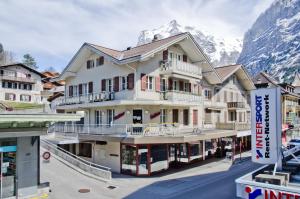 a building in front of a mountain at Apartment Neuenhaus - GRIWA RENT AG in Grindelwald