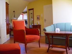 ein Wohnzimmer mit Stühlen, einem Tisch und einem Sofa in der Unterkunft Residenz Lausitz in Graal-Müritz