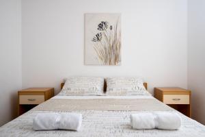 Apartment Toma في بودسترانا: غرفة نوم مع سرير مع موقفين خشبيين