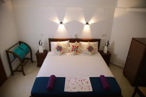 a bedroom with a large bed with four pillows at Aken villa in Hikkaduwa