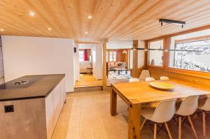uma cozinha e sala de jantar com tecto em madeira em Chic Alpine Apartment for 5 - Perfect for skiers em Grindelwald
