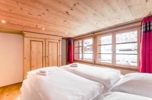 two beds in a room with a large window at Chic Alpine Apartment for 5 - Perfect for skiers in Grindelwald