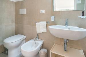 a bathroom with a white sink and a toilet at Villa fronte mare nel Salento in Castro di Lecce