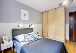 ワルシャワにあるClickTheFlat Sienna Center Apart Roomsのベッドルーム1室(ベッド1台付)、大きな木製キャビネットが備わります。