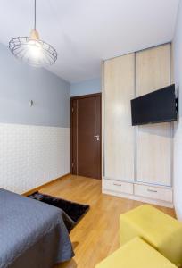 sypialnia z łóżkiem i telewizorem w pokoju w obiekcie ClickTheFlat Sienna Center Apart Rooms w Warszawie