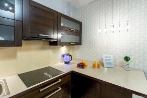 ワルシャワにあるClickTheFlat Sienna Center Apart Roomsのキッチン(茶色のキャビネット、カウンターのオレンジ付)