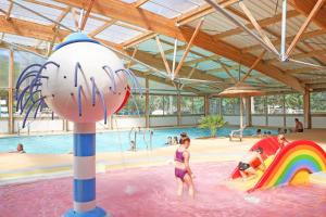 a woman standing in the water at a water park at Camping Signol in Boyard-Ville