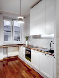 a kitchen with white cabinets and a sink at *ClickTheFlat* Wilcza 33 Street Apart Rooms in the City Center in Warsaw