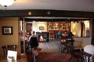 una mujer parada en un restaurante con chimenea en The White Horse Inn Bunkhouse, en Threlkeld