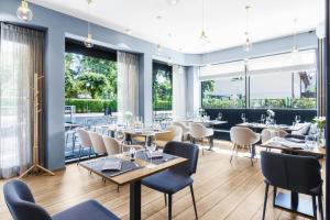- un restaurant avec des tables, des chaises et de grandes fenêtres dans l'établissement Hotel Testa, à Sopot