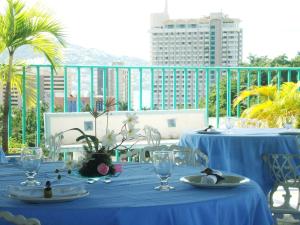 a table with blue table cloth and glasses on a balcony at Suites Angelopolis in Acapulco