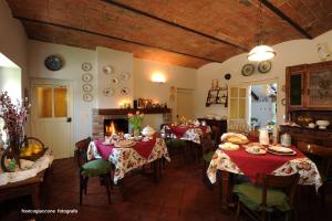 a dining room with two tables and a fireplace at Agriturismo Il Gioco Dell'Oca in Barolo
