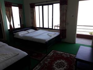 a hotel room with two beds and a window at Himalayan crown lodge in Pokhara