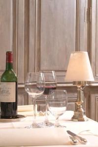 a table with two wine glasses and a bottle of wine at Hotel Claridge in Blankenberge