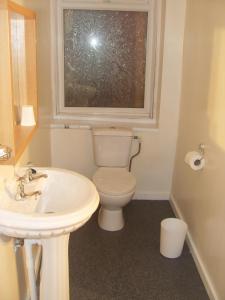 baño con aseo y lavabo y ventana en Chilton Hotel, en Blackpool