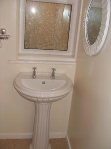 a white sink in a bathroom with a window at Chilton Hotel in Blackpool