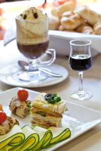 a table with plates of food and a glass of wine at Hotel Estelar Suites Jones in Bogotá