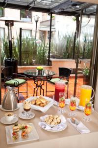 a table topped with plates of food on a patio at Hotel Estelar Suites Jones in Bogotá