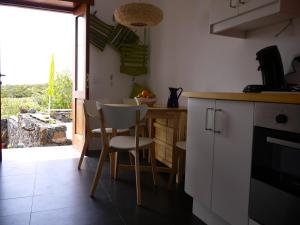 a kitchen with white cabinets and a table and chairs at Casa Las Escaleritas in Isora