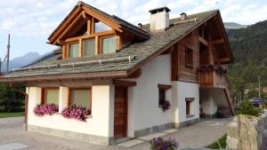 a house in the mountains with flowers on the windows at Agriturismo La Stalla in Bormio