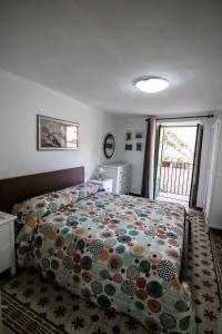 ein Schlafzimmer mit einem Bett mit einer bunten Bettdecke in der Unterkunft Vivere la Ciambra in Monreale