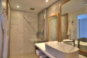 La salle de bains est pourvue d'un lavabo, d'une douche et d'une baignoire. dans l'établissement Bellepierre, à Saint-Denis