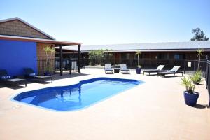 a swimming pool with chairs and a building at Best Western Ascot Lodge Motor Inn in Goondiwindi