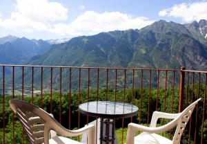 - Balcón con mesa y sillas y vistas a las montañas en Apartamentos Ball Benas Edificio Aigualluts, en Cerler