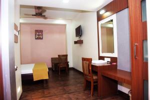 a room with a bed and a desk and a mirror at Hotel Indiana Inn in Navi Mumbai