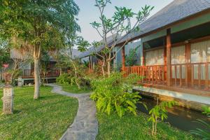 Villa D'Carik Bali في دينباسار: منزل به ممشى بجوار مبنى