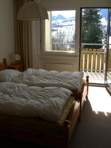un letto in una camera da letto con una grande finestra di Apartment in Disentis a Disentis