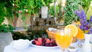 a table with a plate of fruit and two glasses of juice at Villa Andromeda in Chania