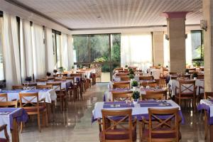 a dining room with tables and chairs and windows at BJ Playa Blanca in Sa Coma +15 photos