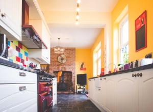 a kitchen with yellow walls and a clock on the wall at Glencoe Villa Guesthouse in Featherstone