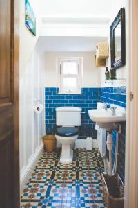 a blue and white bathroom with a toilet and sink at Glencoe Villa Guesthouse in Featherstone