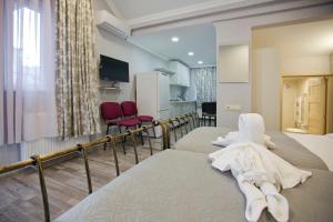 a hotel room with two beds and red chairs at Metekhi Corner Apartments in Tbilisi City