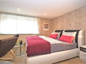 a bedroom with a large bed with red pillows at Holiday flat in Ernstroda near a ski resort in Friedrichroda
