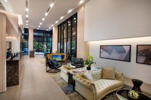 a living room filled with furniture and a large window at Somerset Ekamai Bangkok - SHA Plus Certified in Bangkok