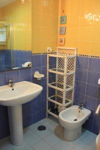 サアラ・デ・ロス・アトゥネスにあるÁtico 2 dormitorios en Atlanterraの青いタイル張りのバスルーム(洗面台、トイレ付)