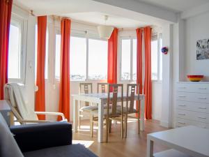 comedor con cortinas naranjas, mesa y sillas en APCOSTAS - Torre del Mar Playa, en Torre del Mar