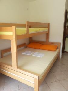 a wooden bunk bed in a small room at Apartmani Ruža in Novalja