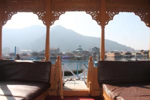 a room with two beds and a view of the water at Iram Houseboats in Srinagar
