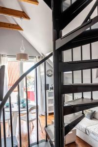 ヤストシェンビャ・グラにあるApartament Przy Klifachのリビングルーム付きの客室で、螺旋階段を利用します。