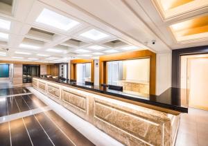 a long bar in a large room with windows at Dang Derm In The Park Khaosan in Bangkok