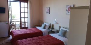 Habitación de hotel con 2 camas y balcón en romanza rooms, en Poulithra
