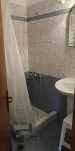 y baño con ducha y cortina de ducha. en romanza rooms, en Poulithra