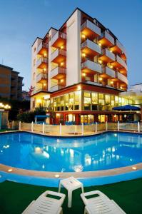 un hotel con piscina frente a un edificio en Hotel Zenith en Cervia