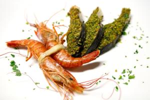 a group of carrots and greens on a white plate at Hotel Villa Margherita in Quercianella