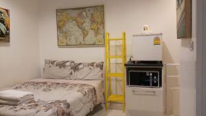 a small room with a bed and a refrigerator at Aquaman @chalong pier in Chalong